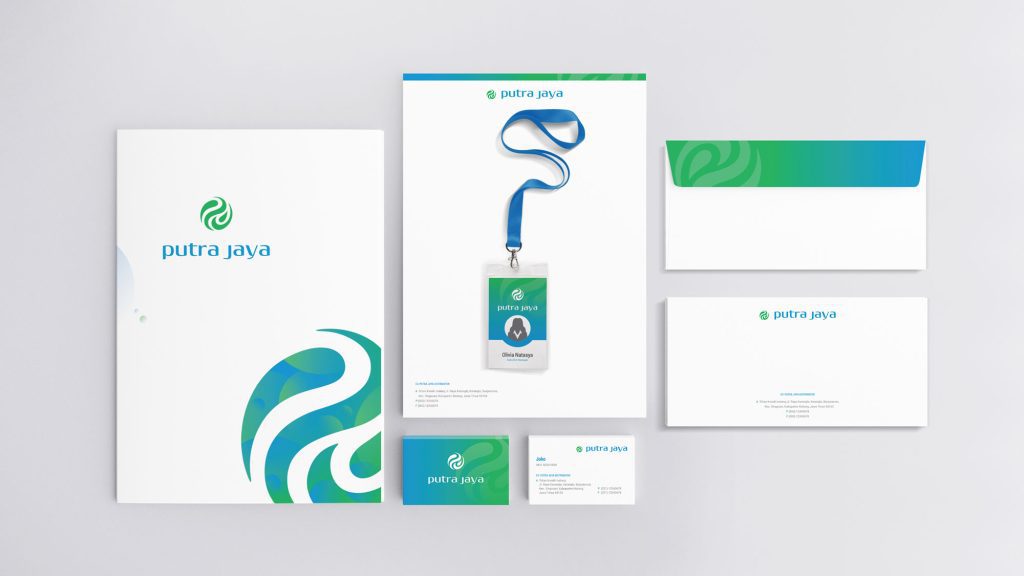 Aplikasi logo dan identitas visual Putra Jaya pada berbagai media. Terlihat desain untuk map folder, kartu nama, amplop, kop surat, dan ID card. Logo Putra Jaya berupa lingkaran hijau dengan bentuk pusaran putih di dalamnya, dan teks "putra jaya" di sampingnya. Warna yang dominan digunakan adalah biru, hijau, dan putih, menciptakan identitas visual yang konsisten.